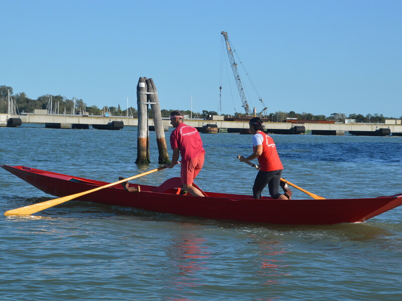 People rowing a red boat
