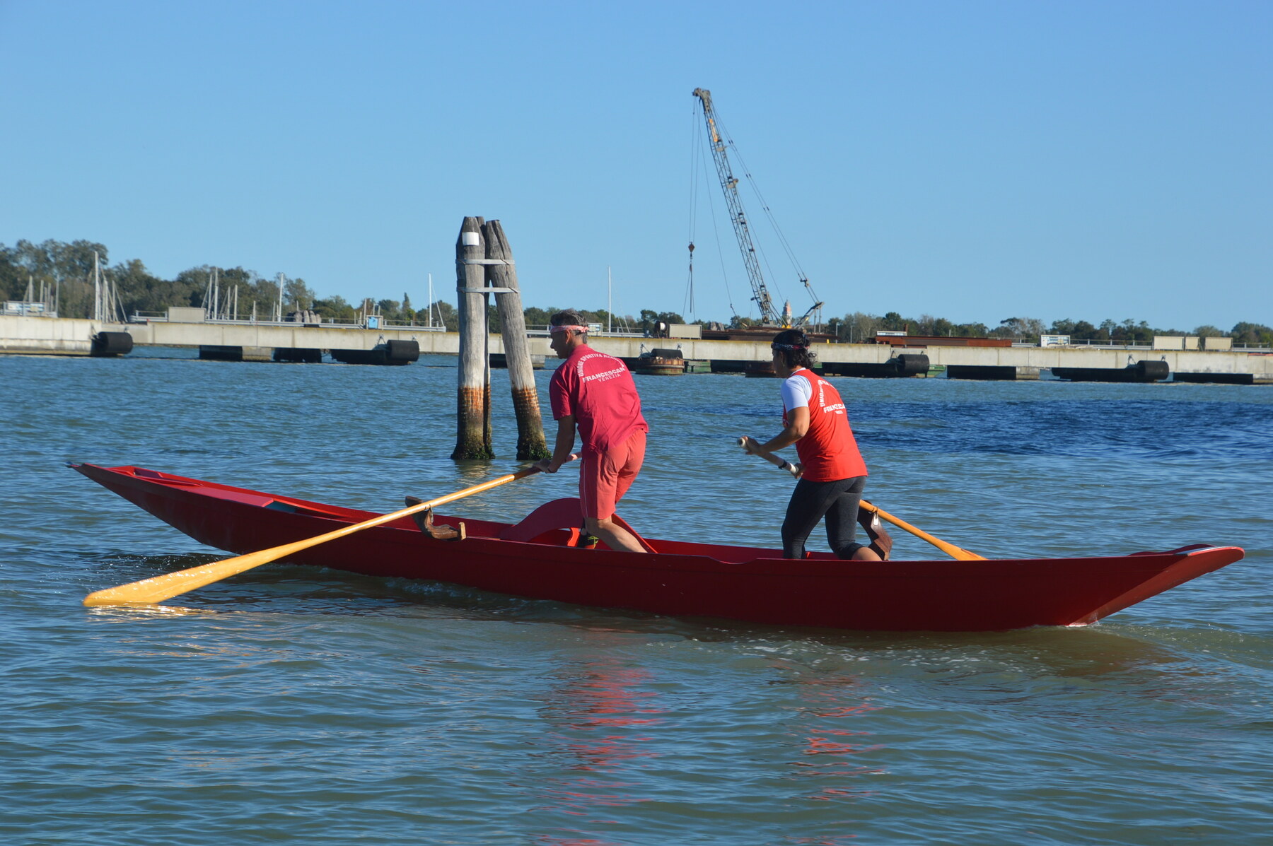 People rowing a red boat